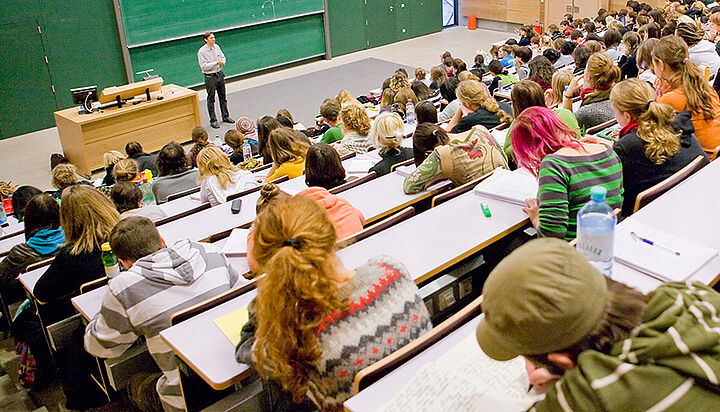 Lehrender und StudentInnen im Hörsaal